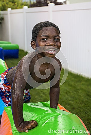 Smiling little boy playing outdoors on an inflatable bounce house Stock Photo