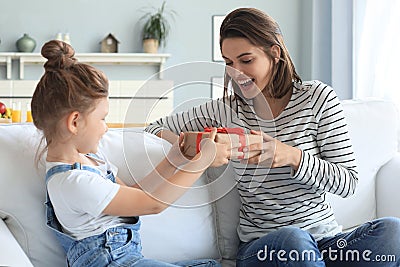 Smiling little child congratulate give gift box to happy mother Stock Photo