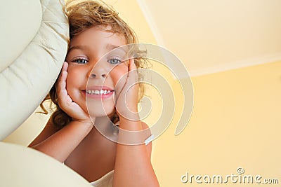 Smiling little girl in cosy room, foreshortening Stock Photo