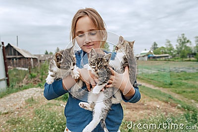 Smiling little girl holds kittens Stock Photo