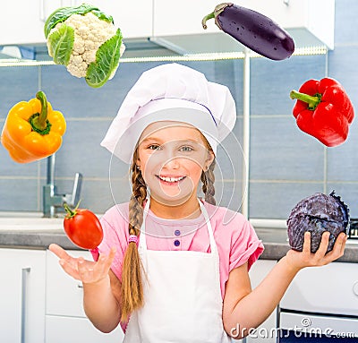 Smiling little girl juggle vegetables Stock Photo