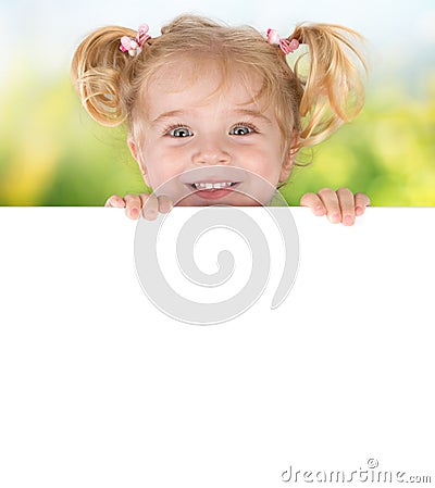 Smiling little girl peeking behind a board Stock Photo