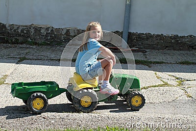 Smiling little girl riding a tractor Editorial Stock Photo