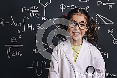 Smiling little girl science student in lab coat Stock Photo