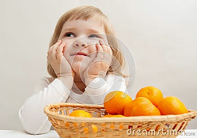 Smiling little girl with tangerines Stock Photo