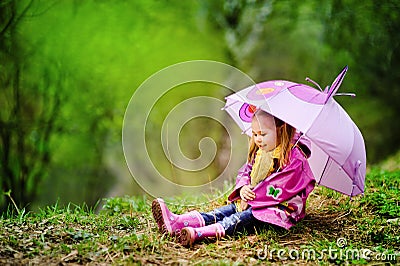 Smiling little girl with umbrella in the park Stock Photo