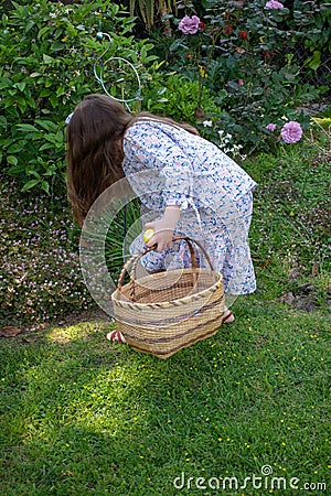 Smiling little latina girl in garden in Spring dress with Basket Stock Photo