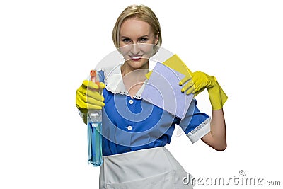 Smiling maid holding rag and pointing spray gun at camera on white background. Stock Photo