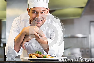 Smiling male chef with cooked food in kitchen Stock Photo