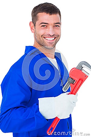 Smiling male mechanic holding monkey wrench Stock Photo