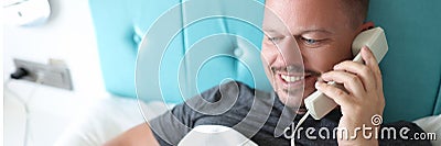 Smiling man calling on reception in hotel, want to order lunch in room Stock Photo