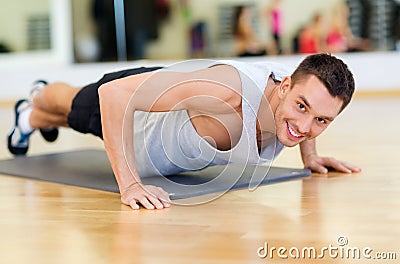 Smiling man doing push-ups in the gym Stock Photo