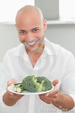 Smiling man holding a plate of broccoli Stock Photo