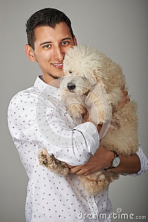 Smiling man holding poodle dog Stock Photo
