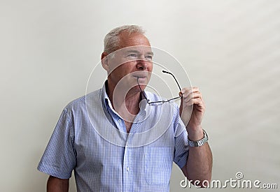 Successful mature man holding glasses in his hand Stock Photo