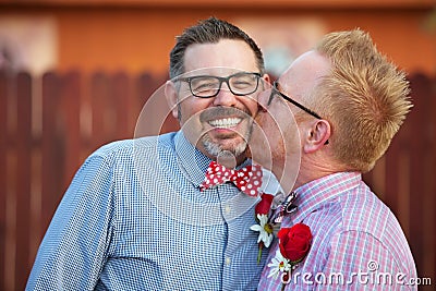 Smiling Man Kissed By Spouse Stock Photo