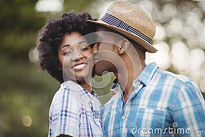 Smiling man kissing her girlfriends cheek Stock Photo