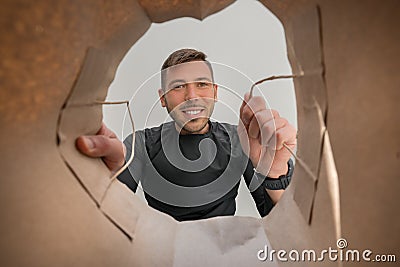 Smiling man looking into paper bag with take home delivery food. Home delivery during self quarantined, COVID-19. Stock Photo