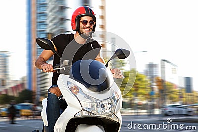 Smiling man on motorcycle ride on city street Stock Photo
