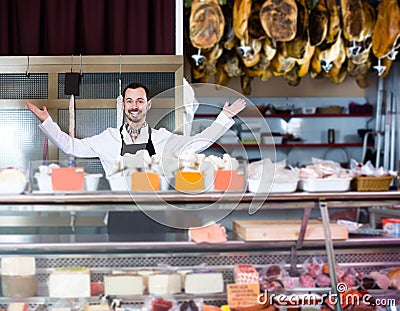 Smiling man seller offering sorts of meat Stock Photo