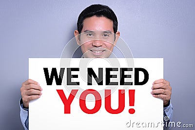 Smiling man showing WE NEED YOU! message Stock Photo