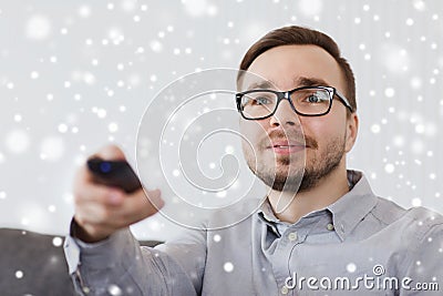 Smiling man with tv remote control at home Stock Photo