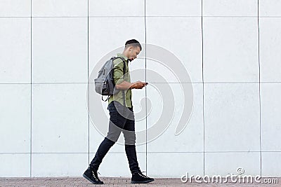 Smiling man walking with backpack smart phone and headphones Stock Photo