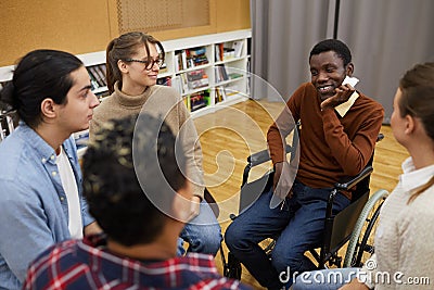 Smiling Man in Wheelchair Sharing with Support Group Stock Photo