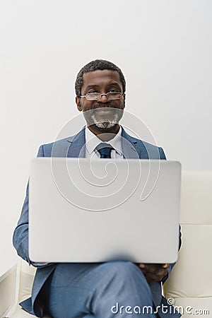smiling African american man working with a laptop and looking Stock Photo