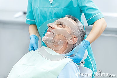 Smiling mature patient and dentist in medical gloves Stock Photo