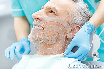 Smiling mature patient and dentist in medical gloves Stock Photo