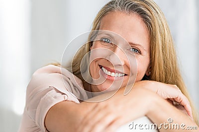 Smiling mature woman on couch Stock Photo