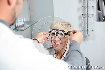 Smiling mature woman having eyesight exam and diopter measurement Stock Photo