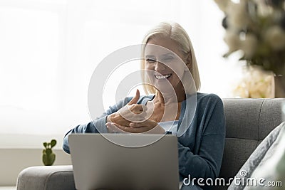 Mature woman with hearing impairment take part in virtual meeting Stock Photo