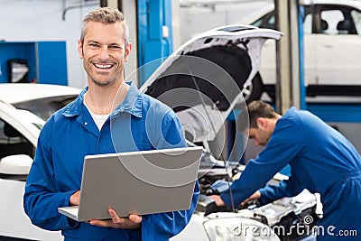 Smiling mechanic using a laptop Stock Photo