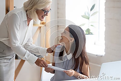 Happy businesswoman congratulate smiling female employee with promotion Stock Photo