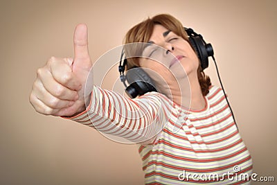 Woman with headphones showing thumb up Stock Photo
