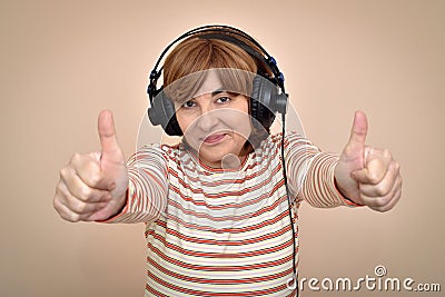 Woman with headphones showing thumbs up Stock Photo
