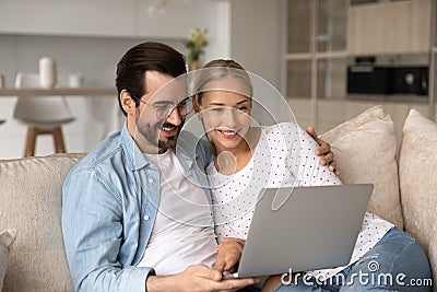 Smiling young couple relax together using laptop Stock Photo