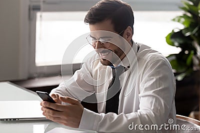 Smiling millennial entrepreneur reading sms with pleasant news. Stock Photo