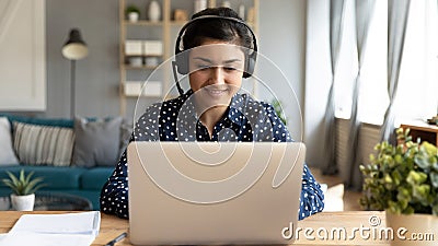 Smiling millennial ethnic female watch webinar on computer Stock Photo