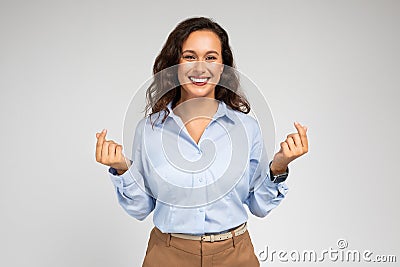 Smiling millennial european woman enjoy success in work, business, show love sign with hands Stock Photo