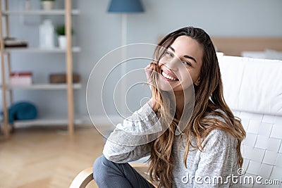 Smiling millennial girl sitting in a cozy chair at home Stock Photo