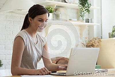 Smiling millennial girl watch webinar on laptop Stock Photo