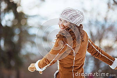 Smiling modern female rejoicing outside in city park in winter Stock Photo