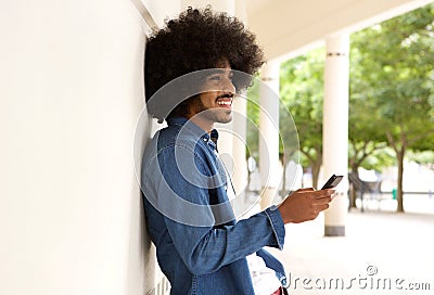 Smiling modern man standing outside with cell phone Stock Photo