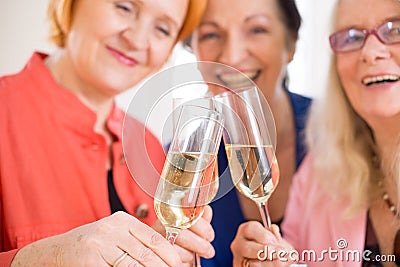 Smiling Mom Friends Tossing Glasses of Champagne Stock Photo