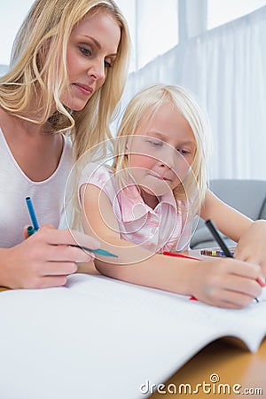 Smiling mother and daughter drawing together Stock Photo