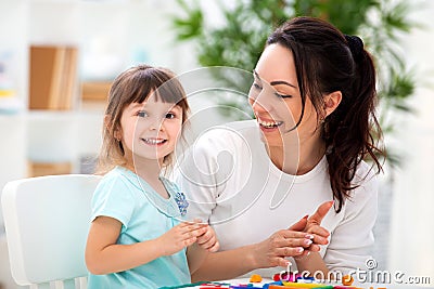 Smiling mother helps a little daughter to sculpt figurines from plasticine. Children`s creativity. Happy family Stock Photo