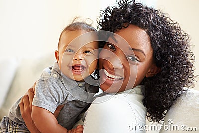 Smiling Mother Playing With Baby Son At Home Stock Photo